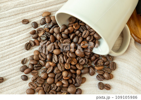 Coffee beans that spread out from a coffee cup Coffee beans that spread out from a coffee cup 109105986