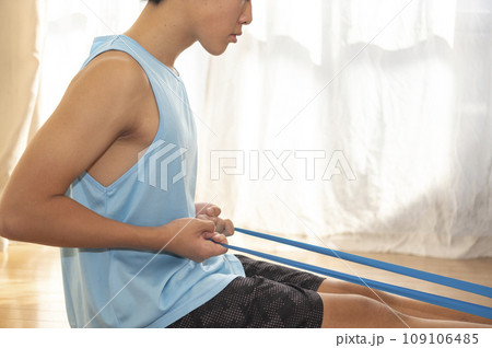 トレーニングチューブで背筋を鍛える10代の男性 109106485