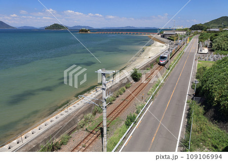 瀬戸内を走るJR予讃線の特急と香川県三豊市三野町の海上に浮かぶ子供の守り神「津嶋神社」 109106994