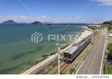 瀬戸内を走るJR予讃線の普通列車と香川県三豊市三野町の海上に浮かぶ子供の守り神「津嶋神社」 109106998