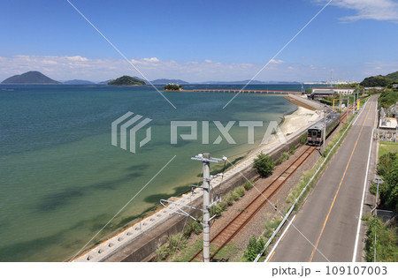 瀬戸内を走るJR予讃線の普通列車と香川県三豊市三野町の海上に浮かぶ子供の守り神「津嶋神社」 109107003