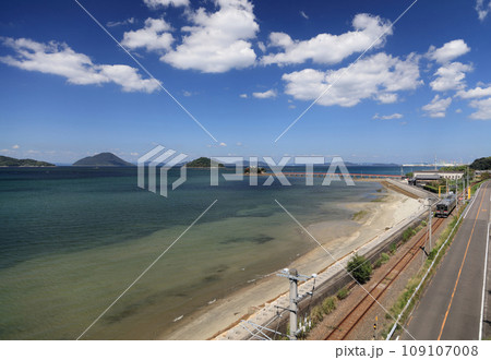 瀬戸内を走るJR予讃線の普通列車と香川県三豊市三野町の海上に浮かぶ子供の守り神「津嶋神社」 109107008