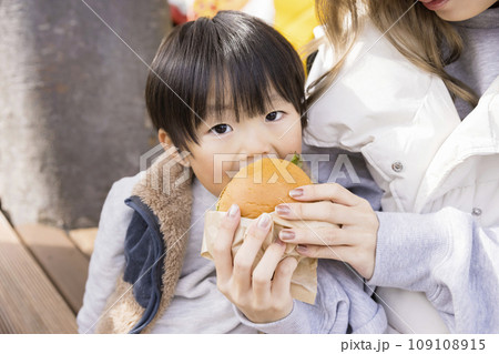 キッチンカーで買ったハンバーガーを食べる親子 キッチンカーで買ったハンバーガーを食べる親子 109108915