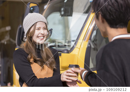 キッチンカーの前でお客さんにコーヒーを渡す店員さん キッチンカーの前でお客さんにコーヒーを渡す店員さん 109109212
