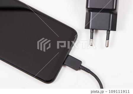 Smartphone with connected plug of charger. Telephone charging 109111911