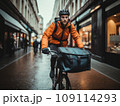 Focused young male delivery man in protective helmet riding bicycle with cardboard boxes on street in city 109114293