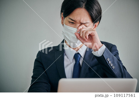 目がかゆくて指で擦る若い男性会社員 109117561