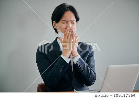 手で口を覆うマスク姿の男性会社員 手で口を覆うマスク姿の男性会社員 109117564