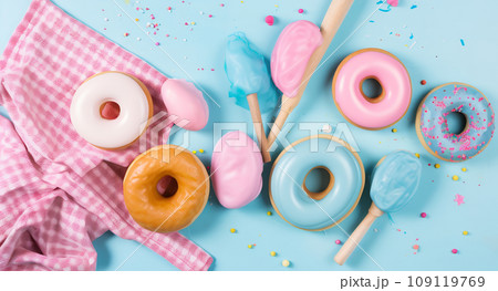 Colorful donuts with glaze, towel and wooden spoons on blue background. Process of making donuts. Top view, copy space 109119769