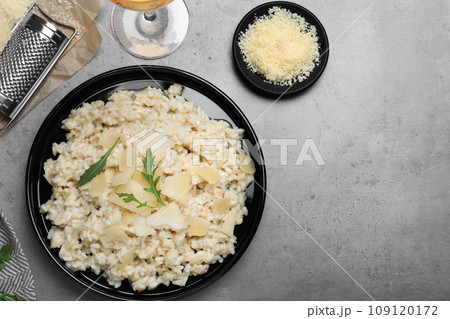 Delicious risotto with cheese on grey table, flat lay 109120172