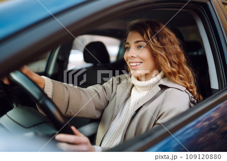 Pretty woman driver smiling to you from car. Automobile Journey, lifestyle concept. Car sharing. Pretty woman driver smiling to you from car. Automobile Journey, lifestyle concept. Car sharing. 109120880