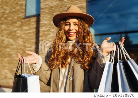 Stylish woman with shopping bags walks through city streets. Spring Style. Lifestyle concept. Stylish woman with shopping bags walks through city streets. Spring Style. Lifestyle concept. 109120970