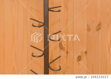 Metal structure clothes hanger hooks on wooden background close-up Metal structure clothes hanger hooks on wooden background close-up 109122017