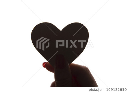 Symbol of heart and love in female hand - silhouette, isolated 109122650