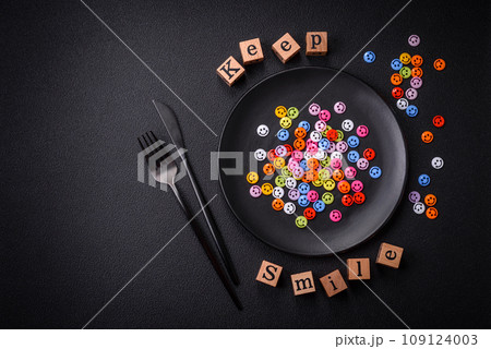 A concept consisting of the inscription of the word smile, with round emoticons on a dark concrete background A concept consisting of the inscription of the word smile, with round emoticons on a dark concrete background 109124003