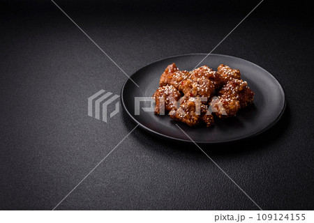 Delicious Asian dish with pieces of chicken in teriyaki sauce with salt and spices 109124155