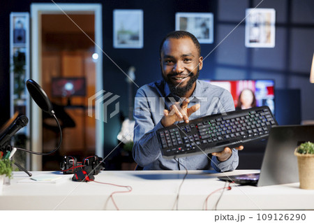 Content creator using high quality recording devices to shoot keyboard review for vlog channel on online platforms. Internet star warmly welcoming dedicated viewers, filming computer peripheral Content creator using high quality recording devices to shoot keyboard review for vlog channel on online platforms. Internet star warmly welcoming dedicated viewers, filming computer peripheral 109126290