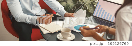 Close up of business colleagues working together with financial statements in stylish meeting room Close up of business colleagues working together with financial statements in stylish meeting room 109126769