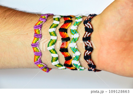 Woven friendship bracelets handmade of thread on males hand. Woven friendship bracelets handmade of thread on males hand. 109128663