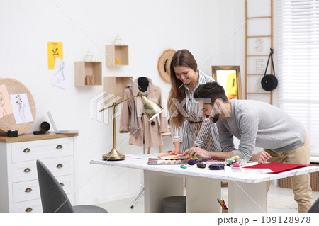 Fashion designers creating new clothes in studio Fashion designers creating new clothes in studio 109128978
