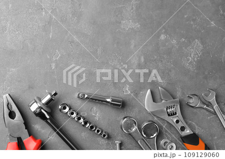 Auto mechanic's tools on grey stone table, flat lay. Space for text 109129060