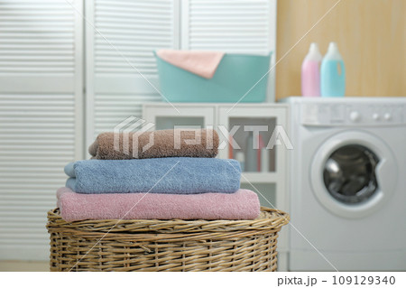 Fresh towels on wicker basket in laundry room 109129340