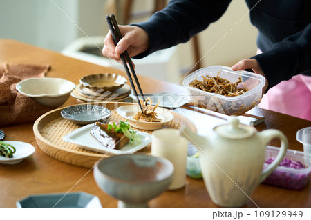 きんぴらごぼうを盛り付ける女性 109129949