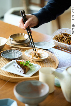 きんぴらごぼうを盛り付ける女性 109129950