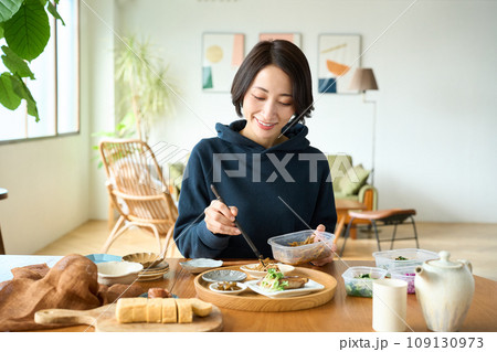 作り置きのおかずを盛り付ける女性 109130973
