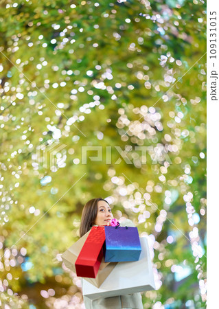 たくさんのショッピングバッグを抱える女性 109131015