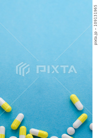 Assorted white and yellow pills on blue table. Medical, pharmacy and healthcare concept. Copy space. Empty place for text or logo. Assorted white and yellow pills on blue table. Medical, pharmacy and healthcare concept. Copy space. Empty place for text or logo. 109131965