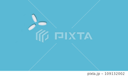 Three round white pills, vitamins on a blue background, flat lay, place for text. Concept of medicines, healthcare, immunity. Three round white pills, vitamins on a blue background, flat lay, place for text. Concept of medicines, healthcare, immunity. 109132002