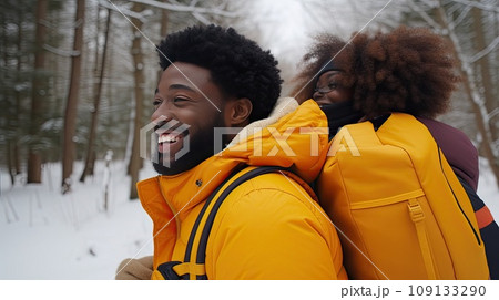 Cheerful group of friends with backpacks for hike walking through winter forest exploring nature. 109133290