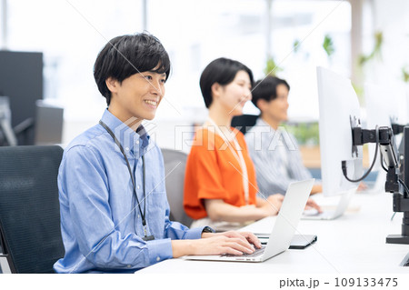 オフィスで打ち合わせをする若い男女のエンジニア オフィスで打ち合わせをする若い男女のエンジニア 109133475