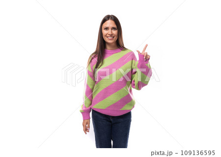 young caucasian woman with black hair dressed in a pink striped sweater points with her hand on a young caucasian woman with black hair dressed in a pink striped sweater points with her hand on a 109136595