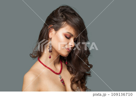 Young jewelry model brunette woman with healthy clear skin and dark brown hair on blue background 109136710