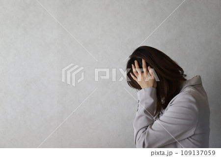 頭を抱えて落ち込む女性 109137059