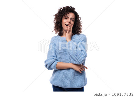 portrait of a charming young caucasian woman with curly dark hair dressed in a casual warm blue portrait of a charming young caucasian woman with curly dark hair dressed in a casual warm blue 109137335