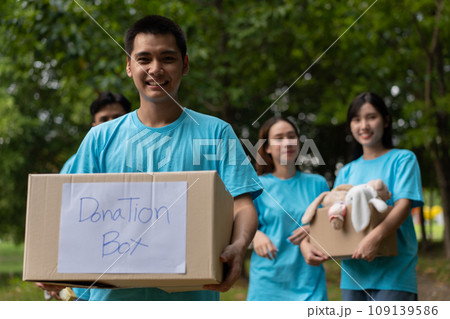 Happy young Asian students diverse volunteers hold donate box and toys for charity to share children and orphanages, a charity for sustainability. Volunteer work lifestyle and social cooperation Happy young Asian students diverse volunteers hold donate box and toys for charity to share children and orphanages, a charity for sustainability. Volunteer work lifestyle and social cooperation 109139586