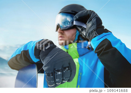 Close Up Of The Ski Goggles Of A Man With The Reflection Of Snowed Mountains. Man In The Background Blue Sky.  Winter Sports. 109141688