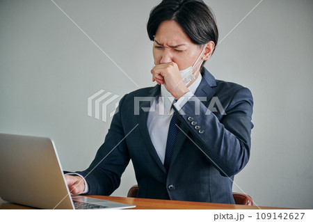 鼻を指で押さえる若い男性会社員 109142627