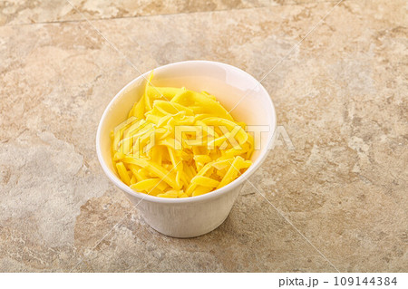 Shredded yellow cheese in the bowl 109144384