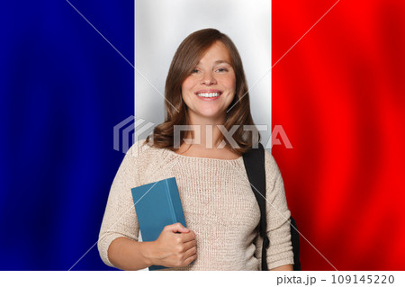 Pretty woman student against French flag background. Travel, education  109145220