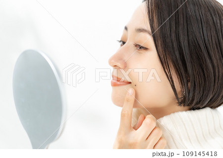 鏡を見てホクロを気にする女性 鏡を見てホクロを気にする女性 109145418
