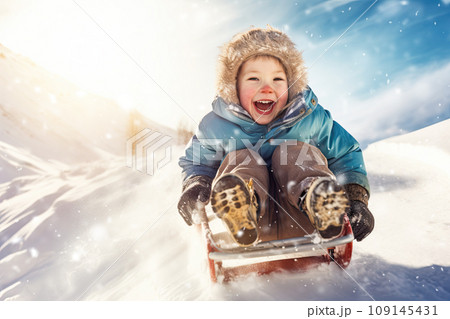 Cheerful kid sliding downhill in winter sunshine. AI content 109145431