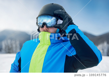 Close Up Of The Ski Goggles Of A Man With The Reflection Of Snowed Mountains. Man In The Background Blue Sky.  Winter Sports. 109145776