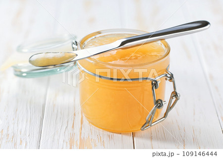 Ginger jam on a white wooden table, selective focus. Jar of ginger jam on the table. Ginger jam on a white wooden table, selective focus. Jar of ginger jam on the table. 109146444