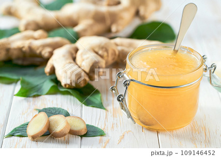 jar with ginger jam and fresh fruits on white wooden table. Delicious homemade natural ginger jam. 109146452