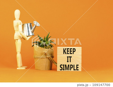 Keep it simple symbol. Concept word Keep it simple on beautiful wooden block. Businessman model. Beautiful orange table orange background. Business motivational keep it simple concept. Copy space. 109147700