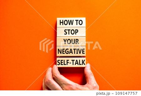 Stop negative self-talk symbol. Concept words How to stop your negative self-talk on wooden block. Psychologist hand. Beautiful orange background. Psychological negative self-talk concept. Copy space Stop negative self-talk symbol. Concept words How to stop your negative self-talk on wooden block. Psychologist hand. Beautiful orange background. Psychological negative self-talk concept. Copy space 109147757